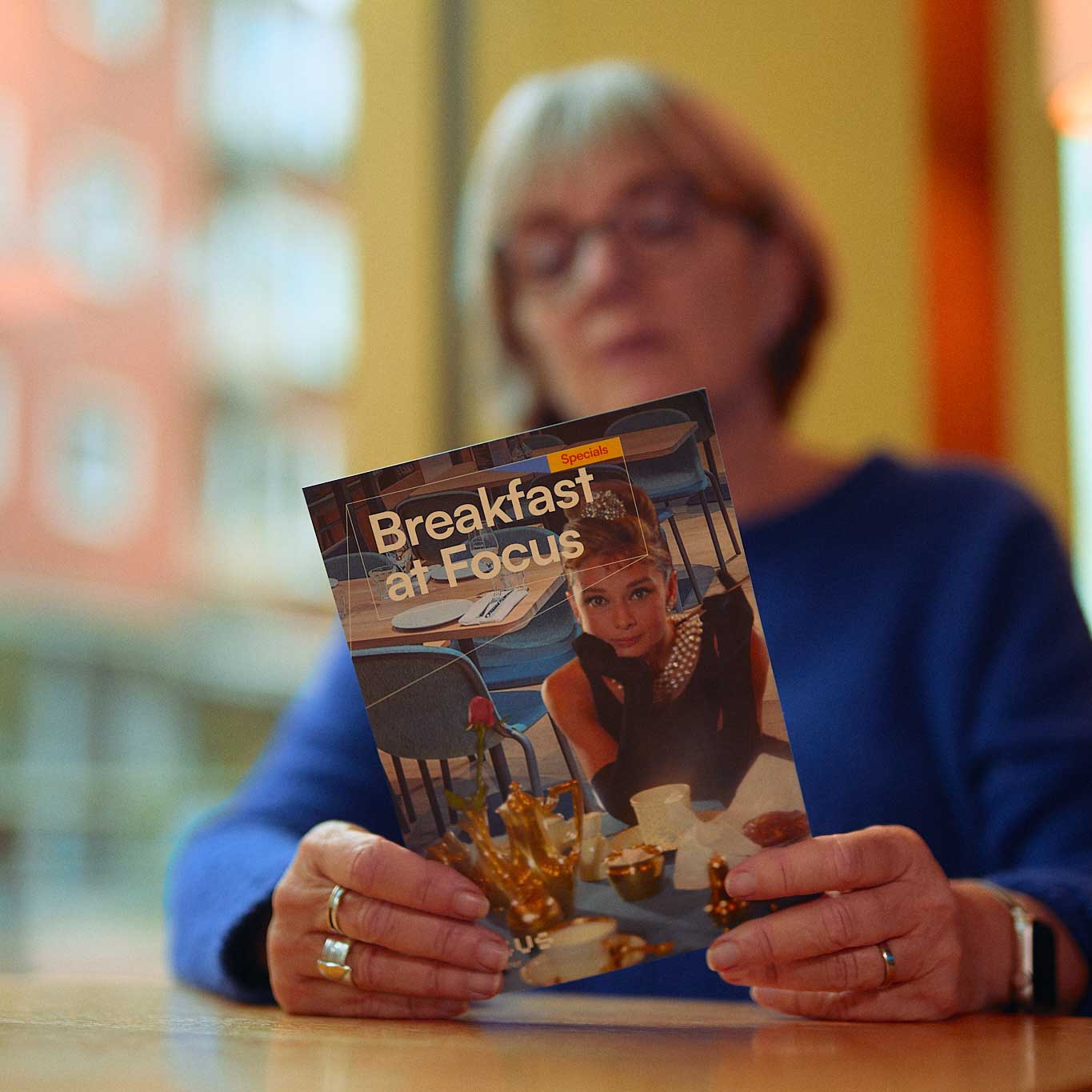 Vrouw houd folder vast van Breakfast at Focus ontwerp door Diep Arnhem